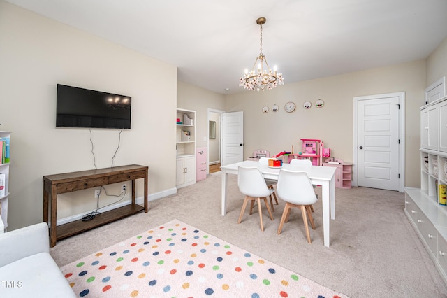 dining space with a chandelier, baseboards, and light colored carpet