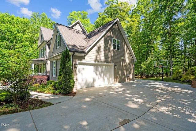 view of property exterior featuring a shingled roof, driveway, and an attached garage