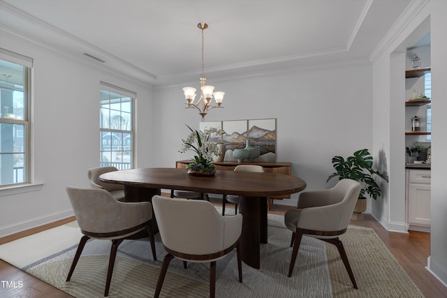 dining room featuring baseboards, visible vents, dark wood-type flooring, crown molding, and a notable chandelier