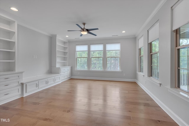 unfurnished living room featuring light wood-type flooring, built in shelves, baseboards, and crown molding