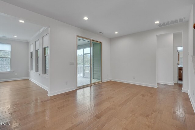 unfurnished room featuring plenty of natural light, light wood-style floors, and visible vents