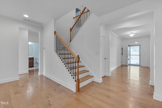 stairway featuring visible vents, recessed lighting, wood-type flooring, crown molding, and baseboards