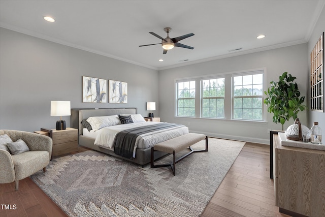 bedroom with recessed lighting, visible vents, wood finished floors, and ornamental molding