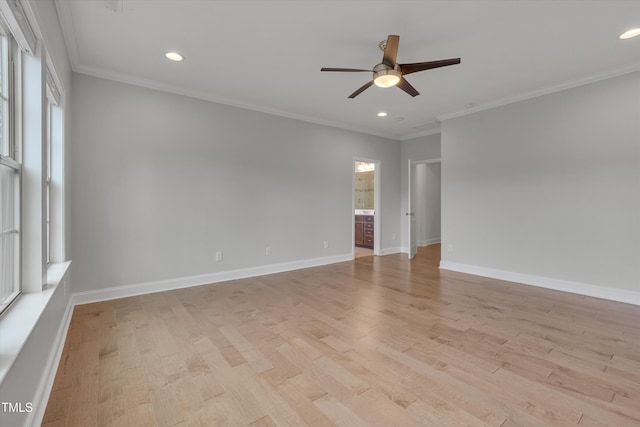 empty room featuring light wood-style flooring, baseboards, and ornamental molding