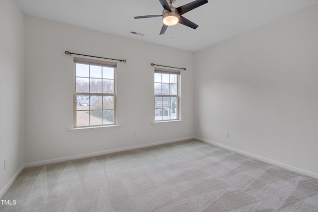 unfurnished room featuring ceiling fan, baseboards, visible vents, and light carpet