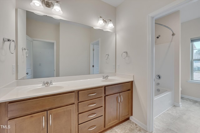 bathroom with double vanity, baseboards, shower / bathing tub combination, and a sink