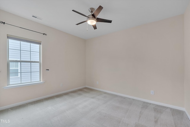 empty room with light carpet, visible vents, baseboards, and a ceiling fan