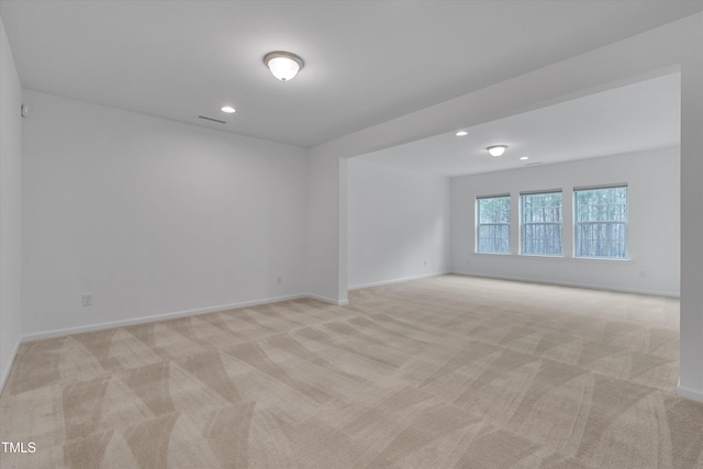 spare room with recessed lighting, baseboards, and light carpet