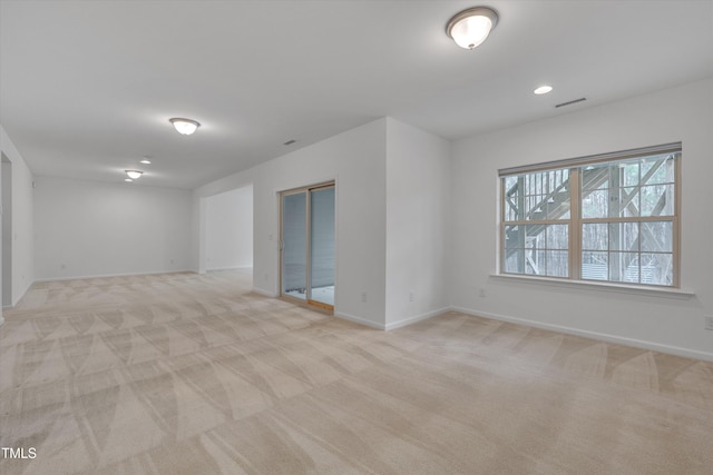 empty room with light carpet, visible vents, recessed lighting, and baseboards