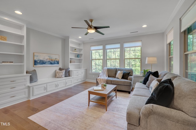 living area with ornamental molding and light wood-style floors