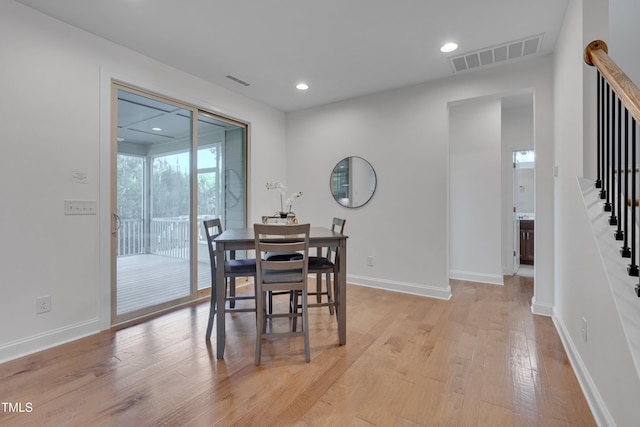dining area featuring stairs, baseboards, light wood-type flooring, and visible vents