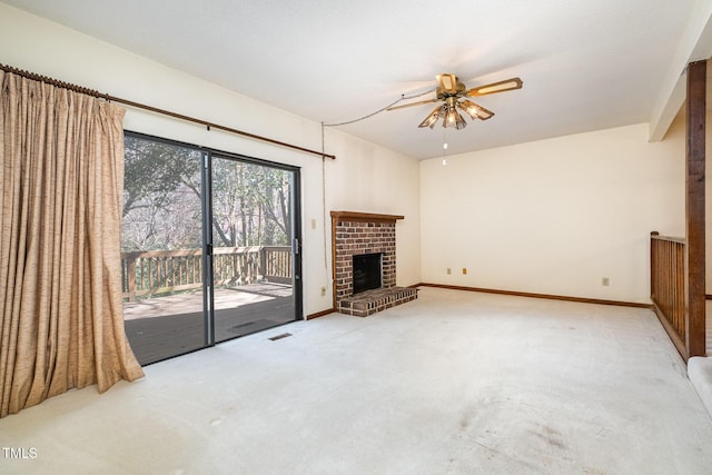 unfurnished living room featuring carpet floors, a brick fireplace, baseboards, and a ceiling fan