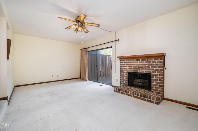 unfurnished living room with carpet floors, a fireplace, a ceiling fan, visible vents, and baseboards