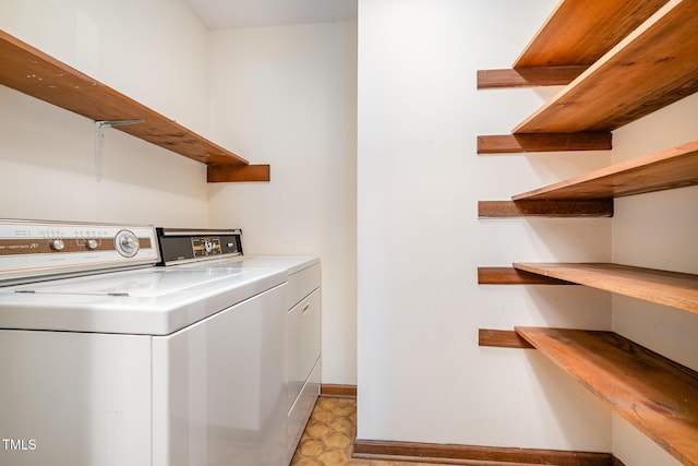 washroom featuring laundry area, baseboards, light floors, and independent washer and dryer