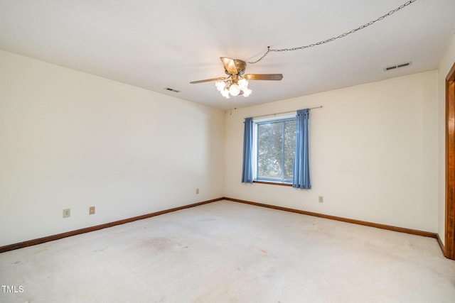 unfurnished room with baseboards, ceiling fan, visible vents, and light colored carpet