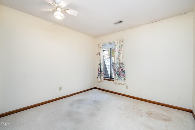 carpeted empty room with visible vents, ceiling fan, and baseboards