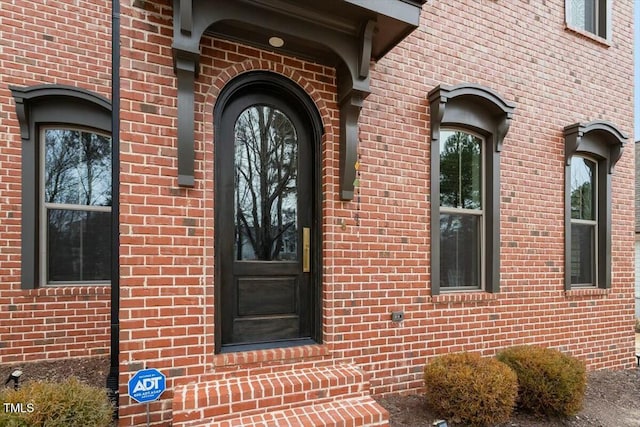 doorway to property featuring brick siding