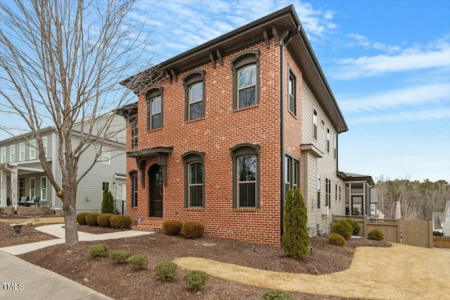 italianate-style house with brick siding and fence