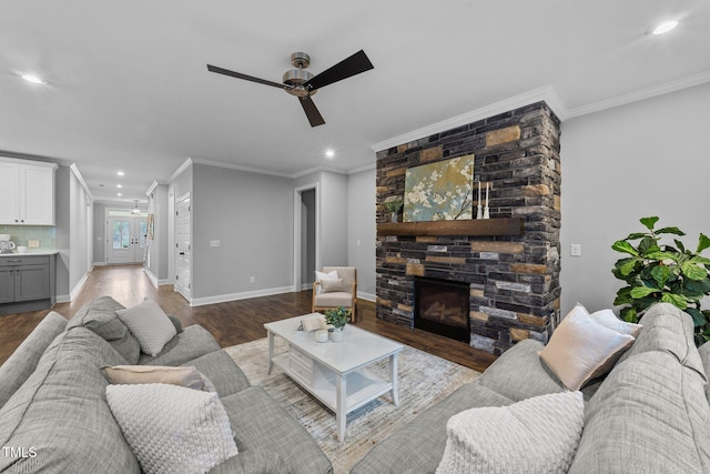 living area with ceiling fan, a stone fireplace, recessed lighting, wood finished floors, and baseboards