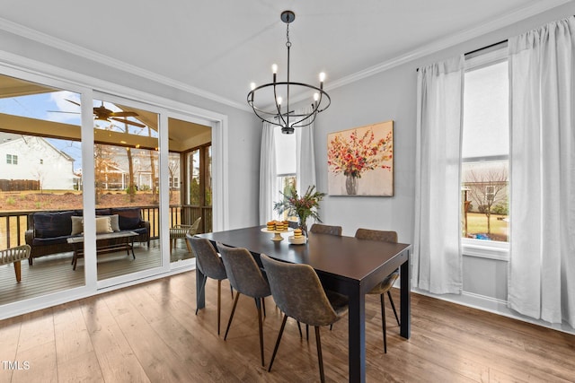 dining area featuring a healthy amount of sunlight, crown molding, and hardwood / wood-style flooring