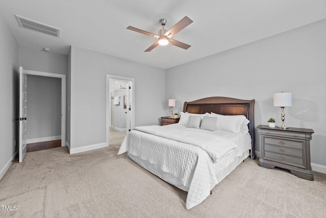 carpeted bedroom with baseboards, visible vents, a ceiling fan, and ensuite bathroom