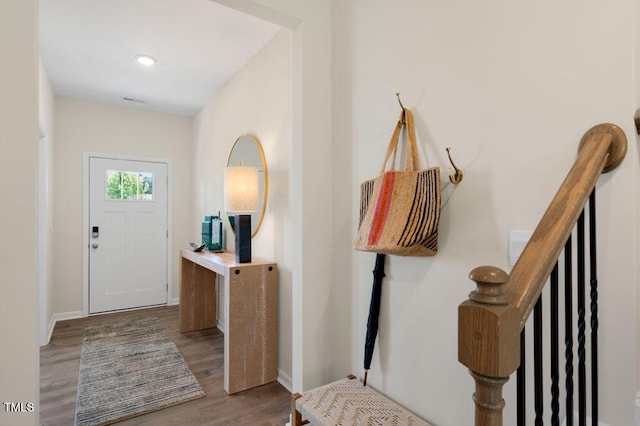 foyer entrance with baseboards, stairway, and wood finished floors