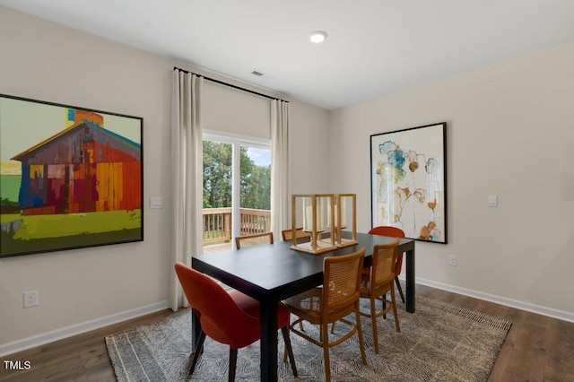 dining space featuring wood finished floors, visible vents, and baseboards