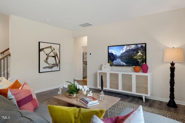 living room with stairs, wood finished floors, visible vents, and baseboards