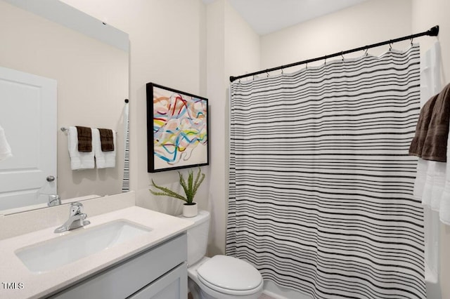 bathroom featuring a shower with shower curtain, vanity, and toilet