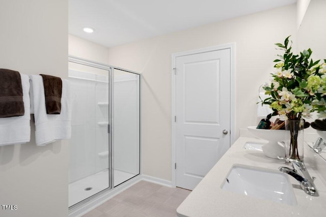 full bath with tile patterned floors, a sink, a shower stall, and double vanity