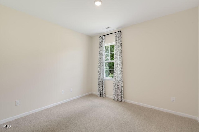 spare room with carpet floors, visible vents, and baseboards