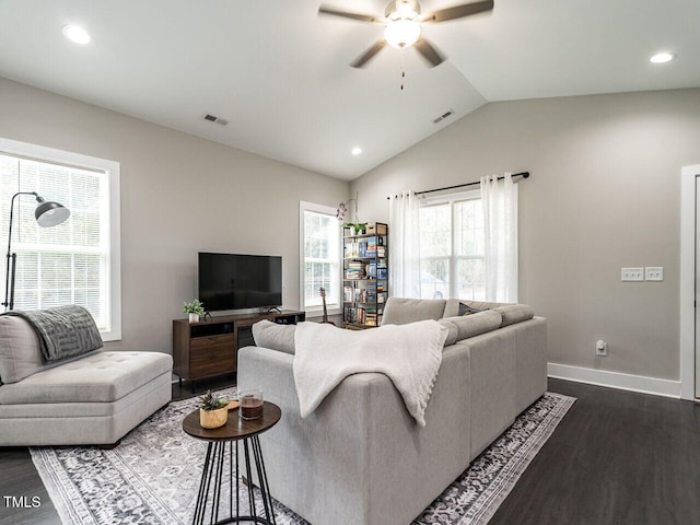 living area featuring dark wood-type flooring, visible vents, vaulted ceiling, and baseboards