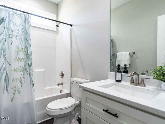 full bath with vanity, shower / bath combo with shower curtain, and toilet