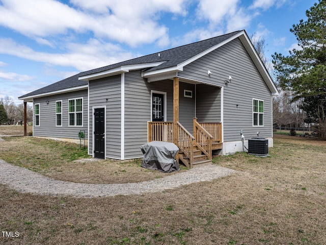 rear view of property with a shingled roof and central AC unit