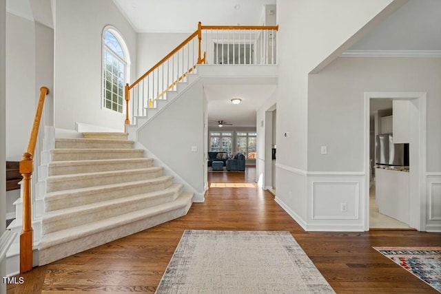 entrance foyer featuring crown molding, plenty of natural light, ceiling fan, and wood finished floors