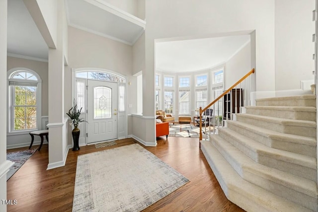 entryway with baseboards, stairway, wood finished floors, and ornamental molding