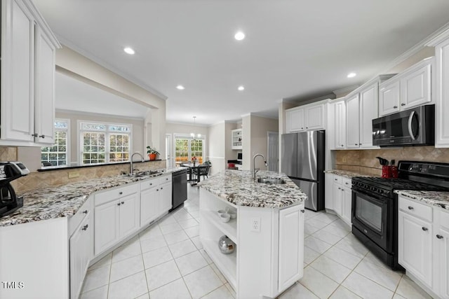 kitchen with an island with sink, black appliances, white cabinetry, and a sink