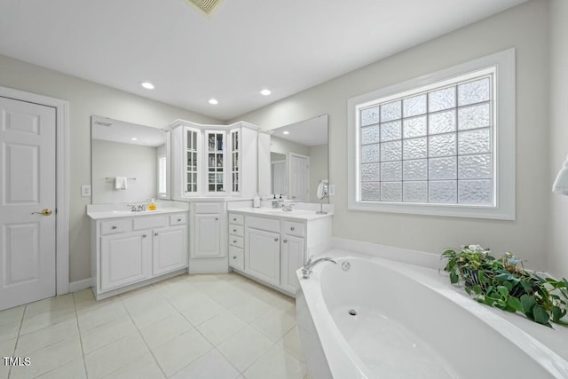 full bath with a garden tub, tile patterned flooring, recessed lighting, a sink, and two vanities