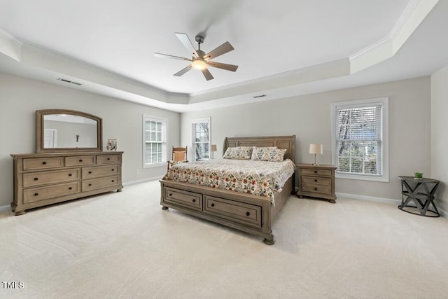 bedroom with baseboards, a raised ceiling, and light colored carpet