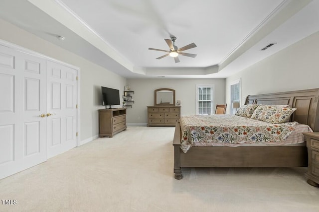 bedroom featuring light colored carpet, visible vents, baseboards, a raised ceiling, and crown molding