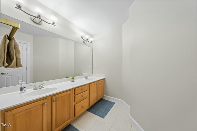 bathroom with double vanity, tile patterned flooring, baseboards, and a sink