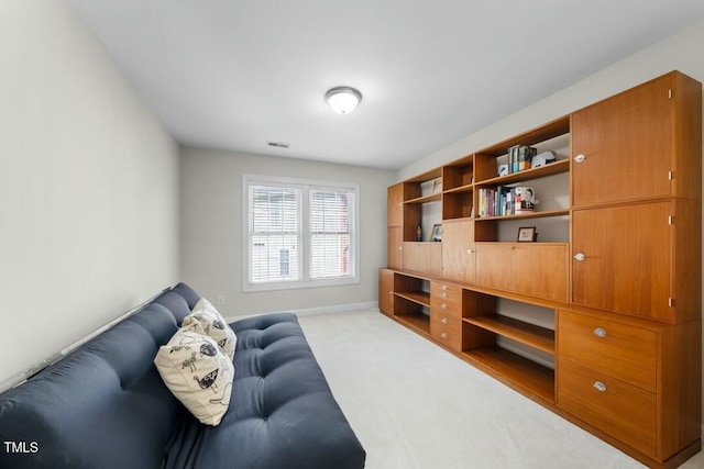 living area featuring baseboards and light colored carpet