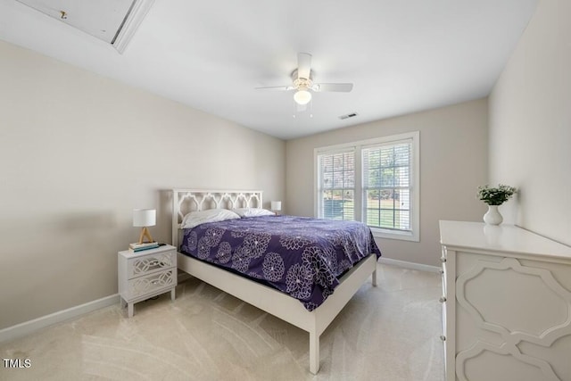 bedroom with ceiling fan, light carpet, visible vents, baseboards, and attic access