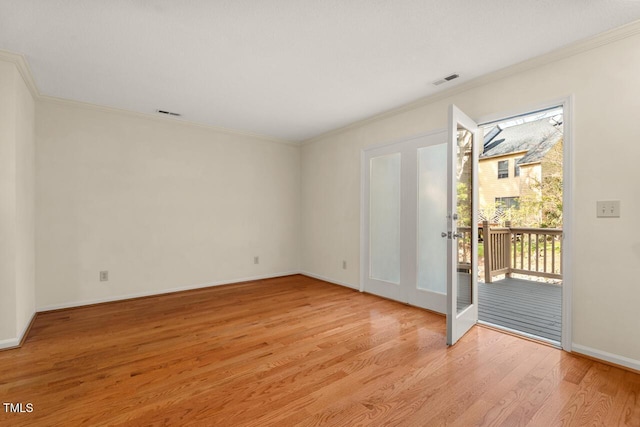 spare room featuring light wood-style floors, crown molding, and french doors