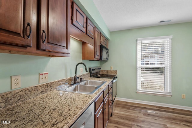 kitchen with appliances with stainless steel finishes, a sink, visible vents, and a healthy amount of sunlight