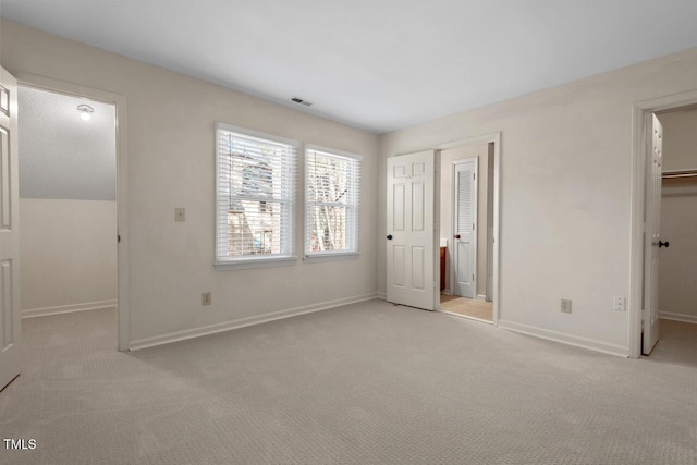 unfurnished bedroom featuring a spacious closet, carpet, visible vents, and baseboards