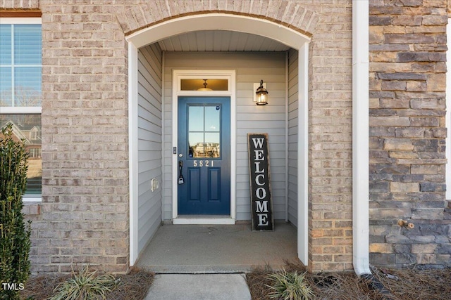 view of exterior entry featuring brick siding