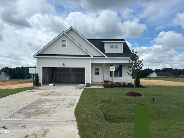 394 Springtooth Dr, Zebulon, NC 27597 - view of front of home with concrete driveway, a front lawn, covered porch, and an attached garage