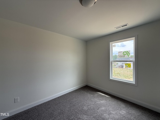 394 Springtooth Dr, Zebulon, NC 27597 - spare room featuring baseboards and dark colored carpet