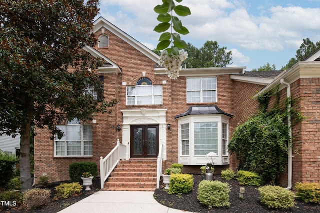 view of front facade with french doors and brick siding